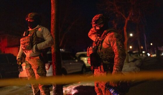 Two federal agents guard a perimeter following a shooting in Minneapolis, Minnesota, on Jan. 14, 2026.