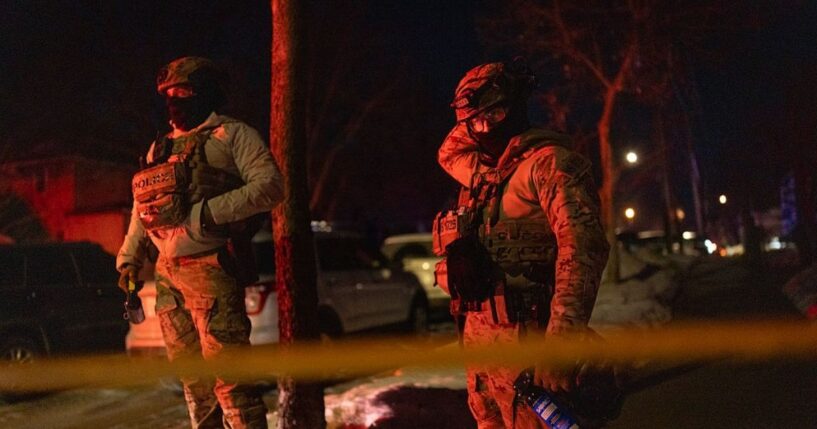 Two federal agents guard a perimeter following a shooting in Minneapolis, Minnesota, on Jan. 14, 2026.