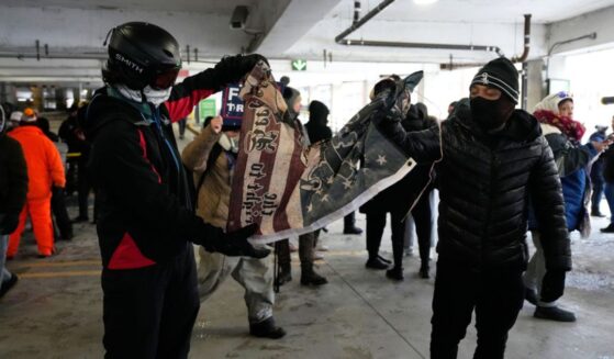 Anti-ICE protesters tear a flag in half in a parking garage on Jan. 17, 2026 in Minneapolis.