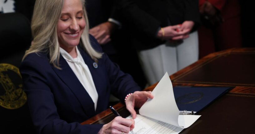 Virginia Governor Abigail Spanberger grins as she signs executive orders shortly after being sworn in as governor at the Virginia State Capitol in Richmond, Virginia, on Jan. 17, 2026.
