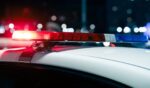 A close up view of flashing police lights on top of a car at night.