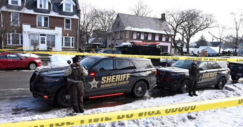Members of the Hennepin County Sheriff's Office look on as people gather near the scene of a shooting Wednesday by an ICE agent during federal law enforcement operations in Minneapolis, Minnesota.