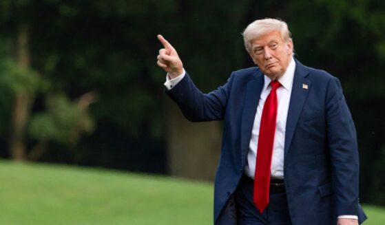 U.S. President Donald Trump walks on the south lawn of the White House and points up at the new flag on July 13, 2025 in Washington, DC.