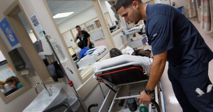 Paramedic Bruno Fernandini moves a patient on his hospital bed at the University of Miami Hospital's Emergency Department on April 30, 2012, in Miami, Florida.