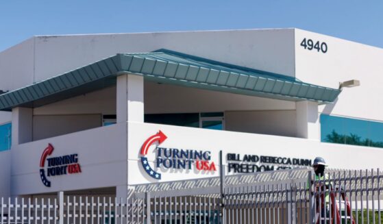 A work crew installs fencing at the headquarters of Turning Point USA near a memorial for Charlie Kirk on Sept. 15, 2025, in Phoenix, Arizona.