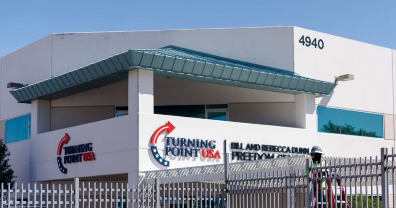 A work crew installs fencing at the headquarters of Turning Point USA near a memorial for Charlie Kirk on Sept. 15, 2025, in Phoenix, Arizona.