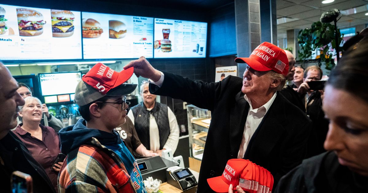 President Donald Trump hands out MAGA hats and greets patrons during a stop at a McDonald's restaurant during a visit to East Palestine, Ohio, on Feb. 22, 2023.