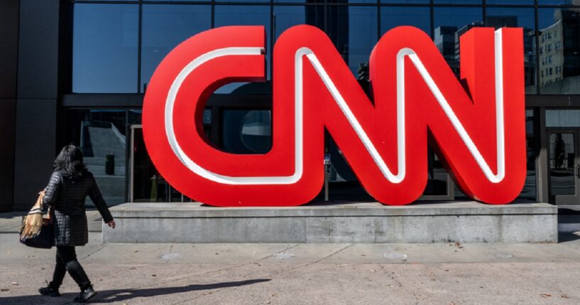 A pedestrian glances at the sign as she passes CNN's Atlanta headquarters building in a November 2022 file photo.
