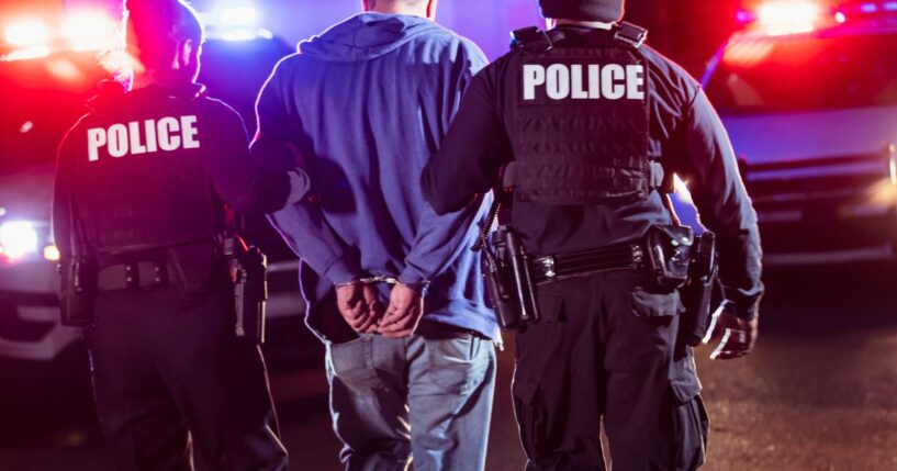 Unidentified officers are seen in a stock photo making an arrest.