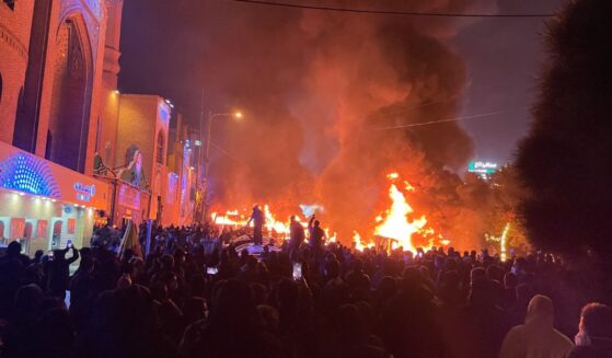 Iranian protesters gather around burning cars near a mosque while blocking a street during a protest in Tehran, Iran, on Jan. 8. The nationwide demonstrations spread across cities with slogans turning from economic grievances to political and anti-government calls. The protests were met by a violent crackdown in which thousands were reportedly killed, according to human rights groups.