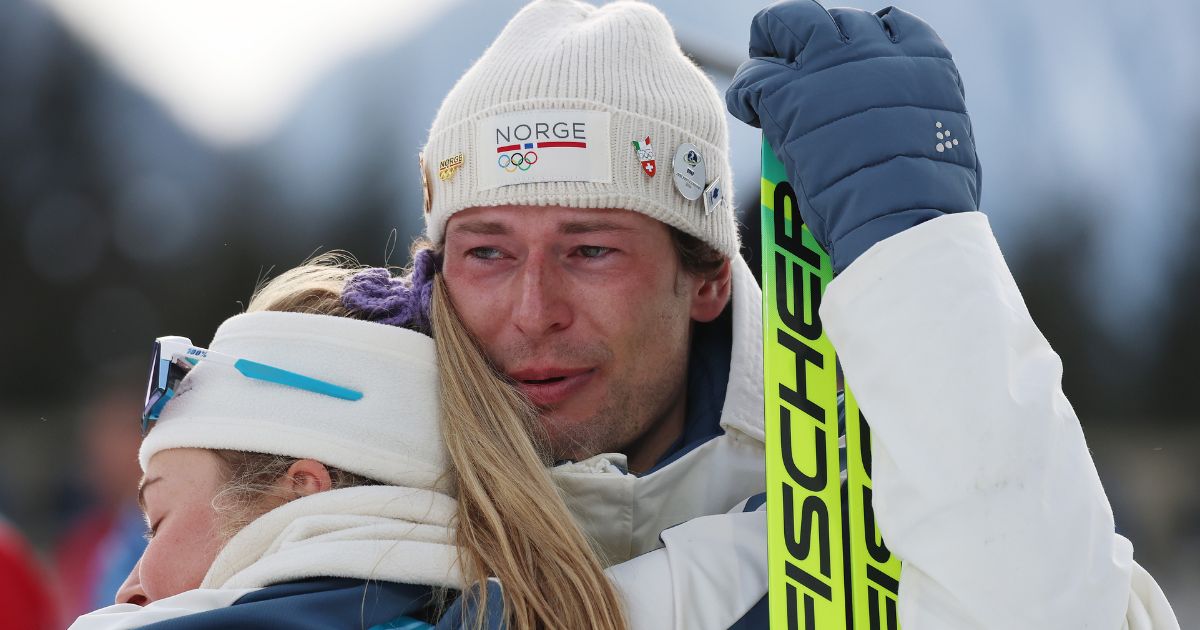 Bronze medalist Sturla Holm Laegreid of Team Norway embraces teammate Ingrid Landmark Tandrevold in Anthill-Anterselva, Italy, on Feb. 10, 2026.