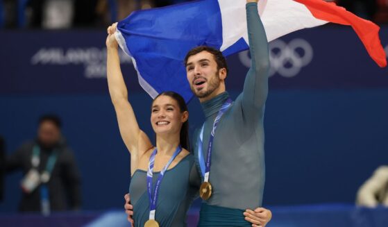 Gold medalists Laurence Fournier Beaudry and partner Guillaume Cizeron of Team France wave the French flag in Milan, Italy, on Feb. 11, 2026.
