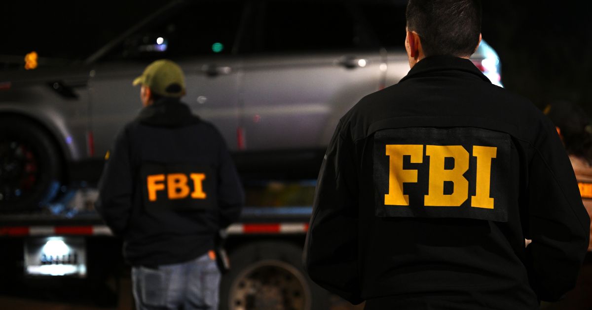 FBI agents watch as a vehicle is towed from the parking lot of a restaurant as they investigate the disappearance of Nancy Guthrie in Tucson, Arizona, on Feb. 13, 2026.