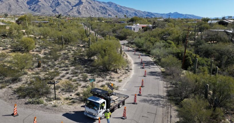 A road crew sets up signs and blocks off a road leading past Nancy Guthrie's residence on Feb. 21, 2026.