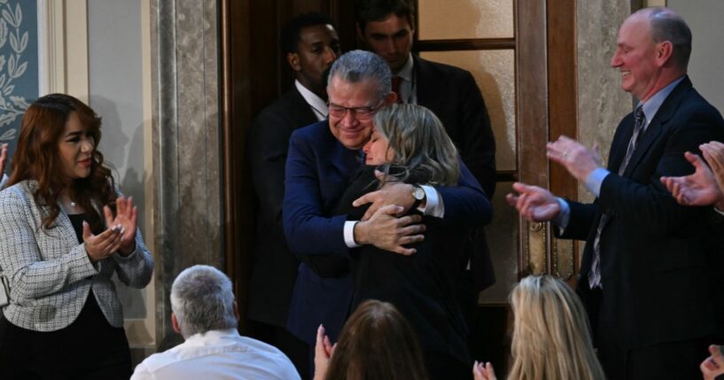 Former Venezuelan presidential candidate and recently released prisoner Enrique Márquez embraces a family member as he is being recognized by President Donald Trump at the State of the Union address in the House Chamber of the US Capitol in Washington, DC on Feb. 24, 2026.