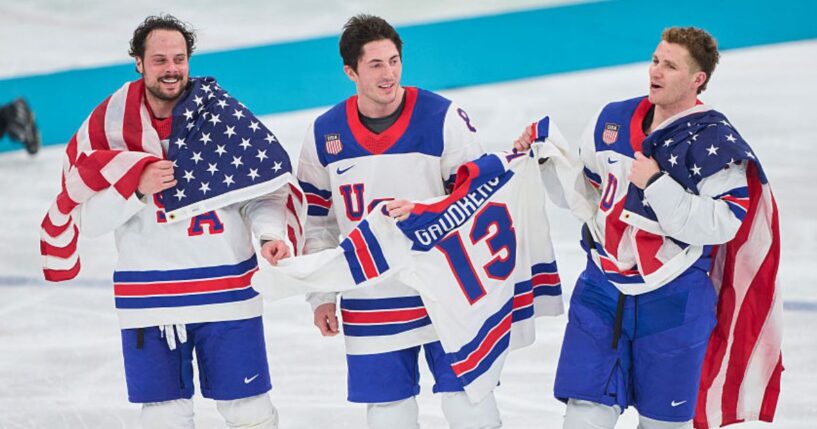 Auston Matthews #34, Zach Werenski #8 and Matthew Tkachuk #19 of Team United States celebrate their team's gold medal victory Sunday in the men`s ice hockey final match between USA and Canada at the 2026 Winter Olympic games in Milan, Italy.