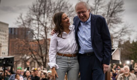 U.S. Rep. Alexandria Ocasio-Cortez of New York and socialist Sen. Bernie Sanders hug on stage in Denver, Colorado, in a March 2025 file photo.
