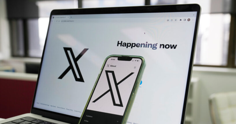 The opening page of X is displayed on a computer and phone on Oct. 16, 2023, in Sydney, Australia.