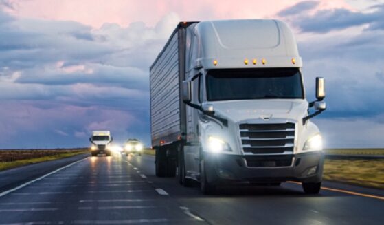 A stock photo of a tractor-trailer rolling down a highway.