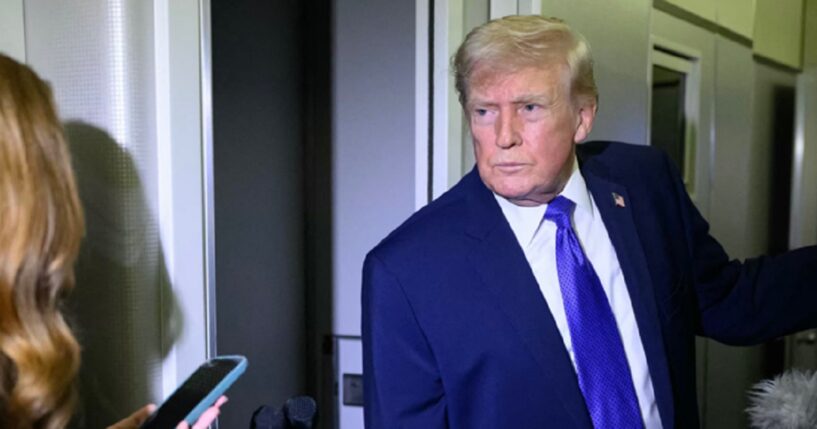 President Donald Trump grimaces while talking to reporters aboard Air Force One on Monday.