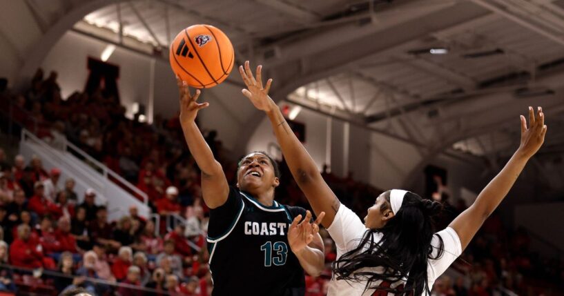 Tracey Hueston of the Coastal Carolina Chanticleers puts up a shot against Mallory Collier of the NC State Wolfpack in the second half at Reynolds Coliseum on Nov. 19, 2025, in Raleigh, North Carolina.