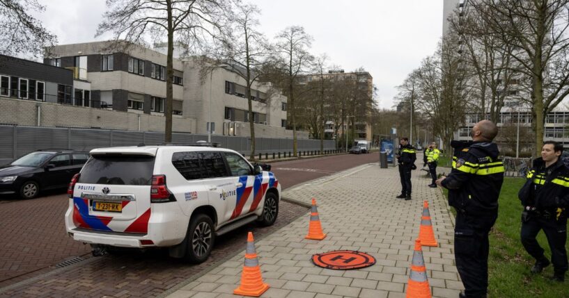Police officers stand outside a Jewish school where an explosion was reported overnight in Amsterdam on March 14, 2026.