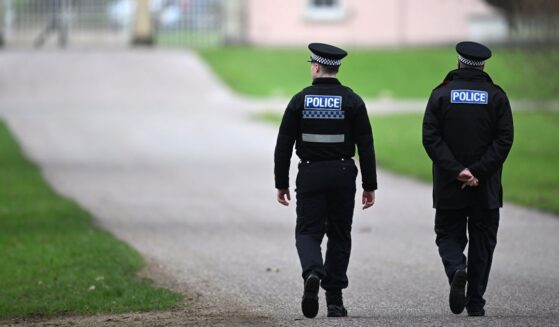 Police officers approach the gates of the Royal Lodge, Andrew Mountbatten-Windsor's former residence in Windsor Great Park, on Feb. 20, 2026, in Windsor, England.