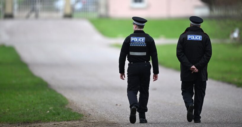 Police officers approach the gates of the Royal Lodge, Andrew Mountbatten-Windsor's former residence in Windsor Great Park, on Feb. 20, 2026, in Windsor, England.