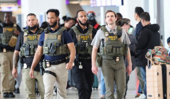 Federal law enforcement agents, including some with U.S. Immigration and Customs Enforcement, walk through LaGuardia Airport in New York on March 23, 2026.