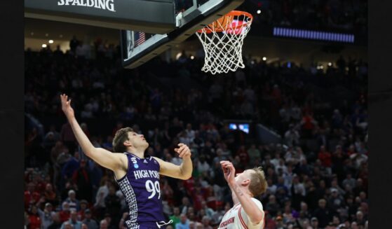 High Point guard Chase Johnston (99) watches his 2-point shot go in the basket during the final seconds of the second half in the first round of the NCAA college basketball tournament against Wisconsin, Thursday in Portland, Ore. The shot put High Point ahead of Wisconsin.