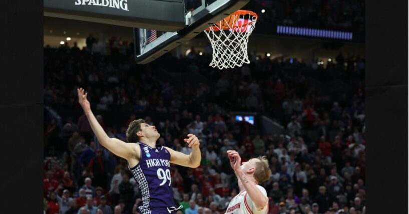 High Point guard Chase Johnston (99) watches his 2-point shot go in the basket during the final seconds of the second half in the first round of the NCAA college basketball tournament against Wisconsin, Thursday in Portland, Ore. The shot put High Point ahead of Wisconsin.