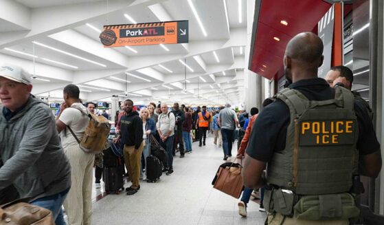 Ice agents look on Monday as travelers stand in long lines at Atlanta Hartsfield-Jackson International Airport in Atlanta, Georgia. The travel disruptions continue as hundreds of TSA agents quit or work without pay during a partial government shutdown. President Donald Trump said ICE agents will be deployed to U.S. airports, with border czar Tom Homan in charge of the effort.