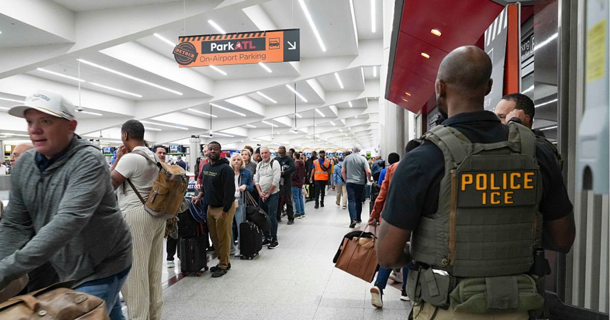 Ice agents look on Monday as travelers stand in long lines at Atlanta Hartsfield-Jackson International Airport in Atlanta, Georgia. The travel disruptions continue as hundreds of TSA agents quit or work without pay during a partial government shutdown. President Donald Trump said ICE agents will be deployed to U.S. airports, with border czar Tom Homan in charge of the effort.