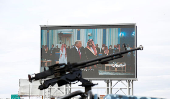 Houthis-mounted machine gun across from screen of Donald Trump meeting with Middle Eastern leaders.
