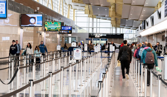 Travelers walk in the lines of Ronald Reagan International Airport on March 30, 2026.