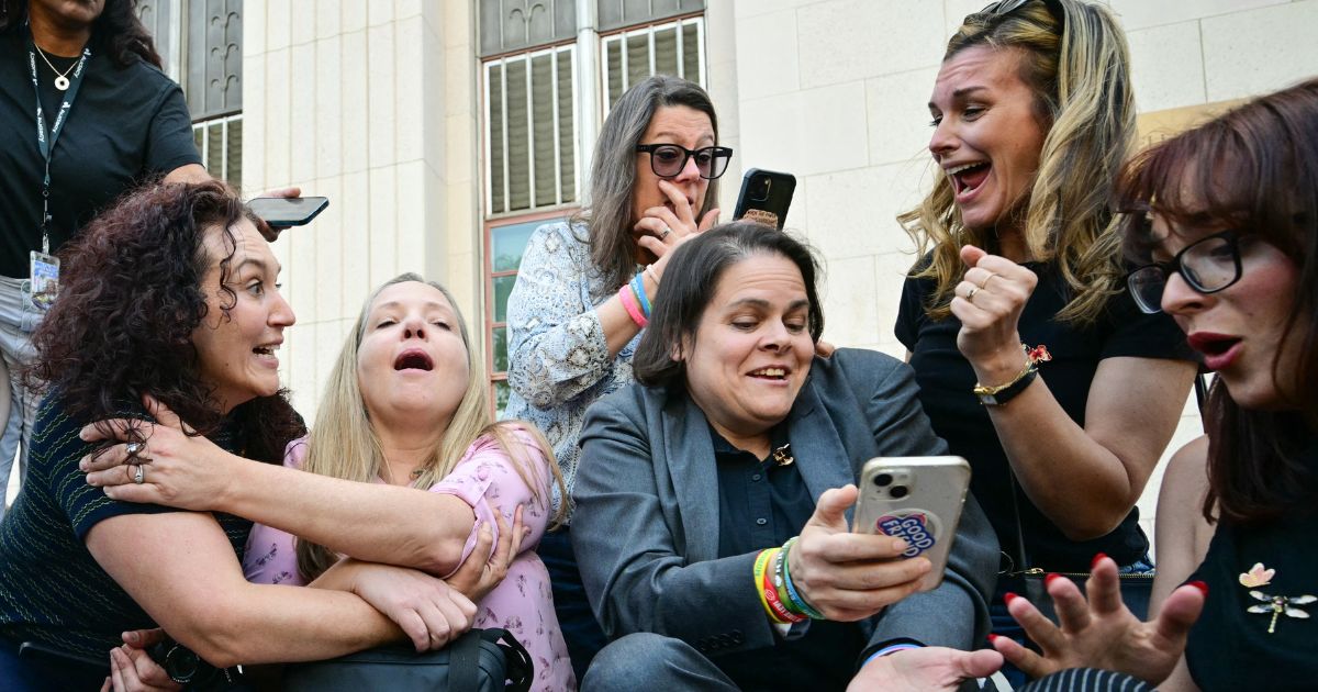 Laura Marquez-Garrett, center, in gray blazer, plaintiffs' attorney for the Social Media Victims Law Center, celebrates with family members of victims outside the Los Angeles Superior Court Wednesday as they react to news that a jury has found Meta and YouTube liable in a social media addiction trial. The jury found Meta and YouTube liable for harming a young woman through the addictive design of their social media platforms and ordered the companies to pay $3 million in damages.