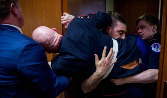 Protester Brian McGinnis is dragged out of a Senate Armed Services Subcommittee hearing on Capitol Hill and is stuck in a door on March 4, 2026.