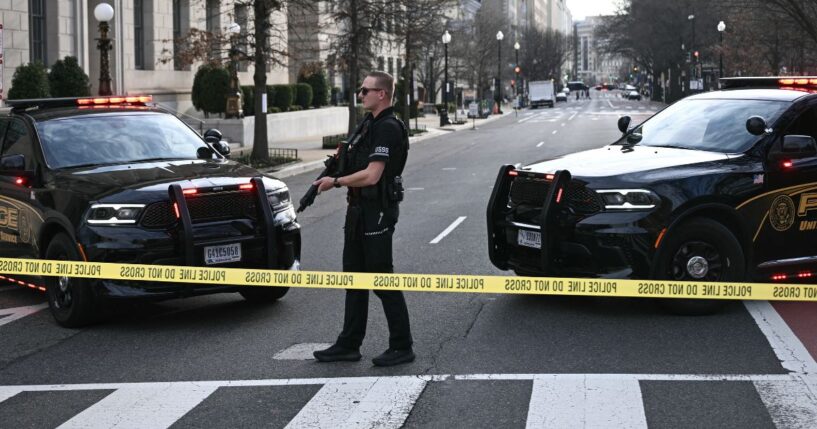 A member of the U.S. Secret Service patrols the scene where a van plowed into barricades near the White House in Washington, DC on March 11, 2026.