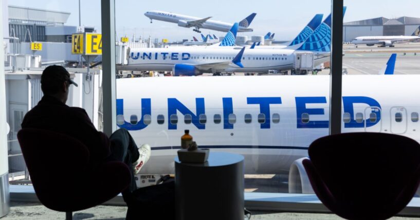 A man sits in an airport overlooking a United Airlines plane at San Francisco International Airport on Aug. 31, 2025.