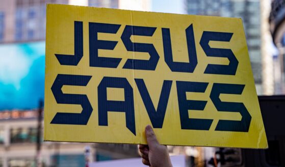 A close up of a yellow sign that says "Jesus saves."
