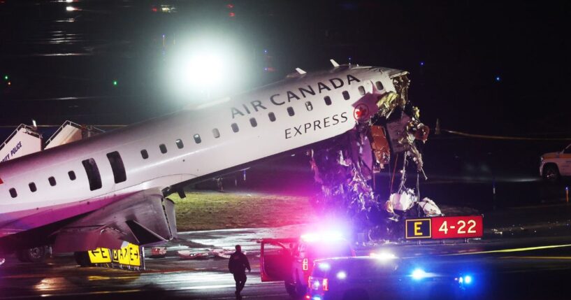 An Air Canada Express plane sits on the tarmac after a crash at LaGuardia Airport on March 23, 2026.