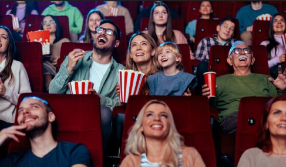 A crowd in a movie theater laughing at what they're watching.
