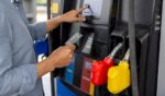 A man uses a credit card to pay for gas at a gas station.
