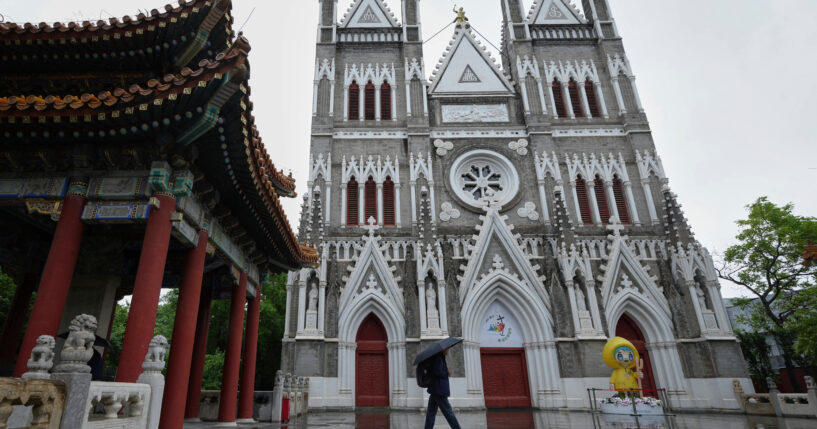 A man walks out from a pavilion near the Xishiku Catholic Church during a rainy day in Beijing, May 9, 2025.
