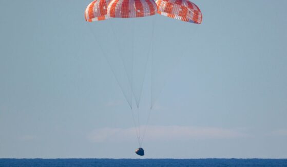 In this handout photo provided by NASA, NASA's Orion spacecraft with Artemis II crewmembers NASA astronauts Reid Wiseman, commander; Victor Glover, pilot; Christina Koch, mission specialist; and Canadian Space Agency astronaut Jeremy Hansen, mission specialist aboard is seen under parachutes as it lands in the Pacific Ocean off the coast of California on April 10, 2026.