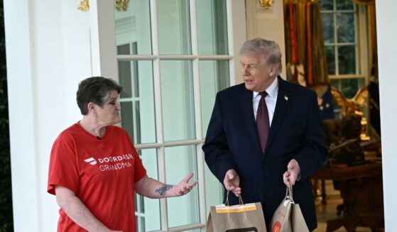 President Donald Trump speaks with a DoorDash delivery worker after she delivered McDonald's at the Oval Office at the White House in Washington, D.C., on April 13, 2026.