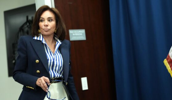 A teenager driver committed a minor offense is handing over her license to a police officer reaching toward the open window.