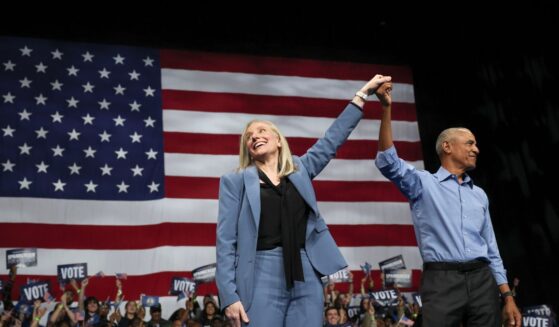 Former President Barack Obama and Virginia Gov. Abigail Spanberger, raise their arms together during a campaign rally in the Chartway Arena on Nov. 1, 2025, in Norfolk, Virginia.
