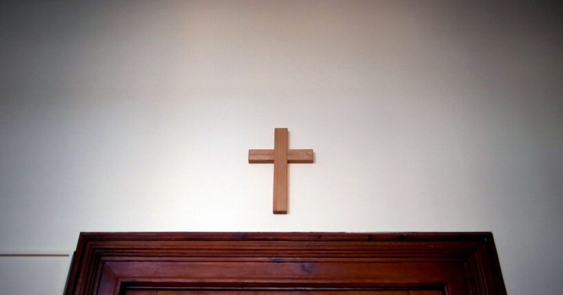A wooden cross hangs over a door in an empty classroom at the Domgymnasium grammar school in Magdeburg, eastern Germany, on March 25, 2020.