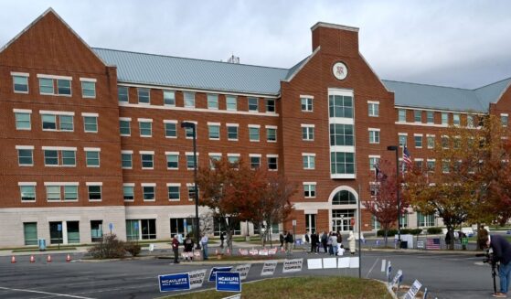 Students, parents, and others hold signs outside the Loudoun County school board meeting on Oct. 26, 2021, in Ashburn, Virginia.